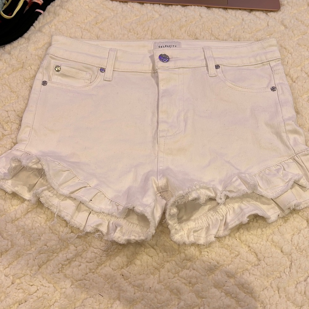 White jean shorts with ruffle bottom.
